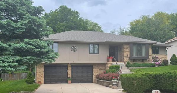 Split-level home after insurance claim makeover — new roof, gutters, and paint