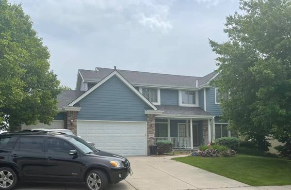 Two-story home with new blue Diamond Kote siding and Malarkey Legacy roof